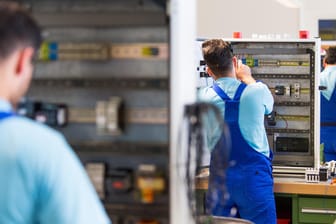 Drei junge Männer arbeiten an der Verdrahtung eines Schaltschranks: Ausländische Abschlüssen werden häufig nicht anerkannt. (Archivbild)