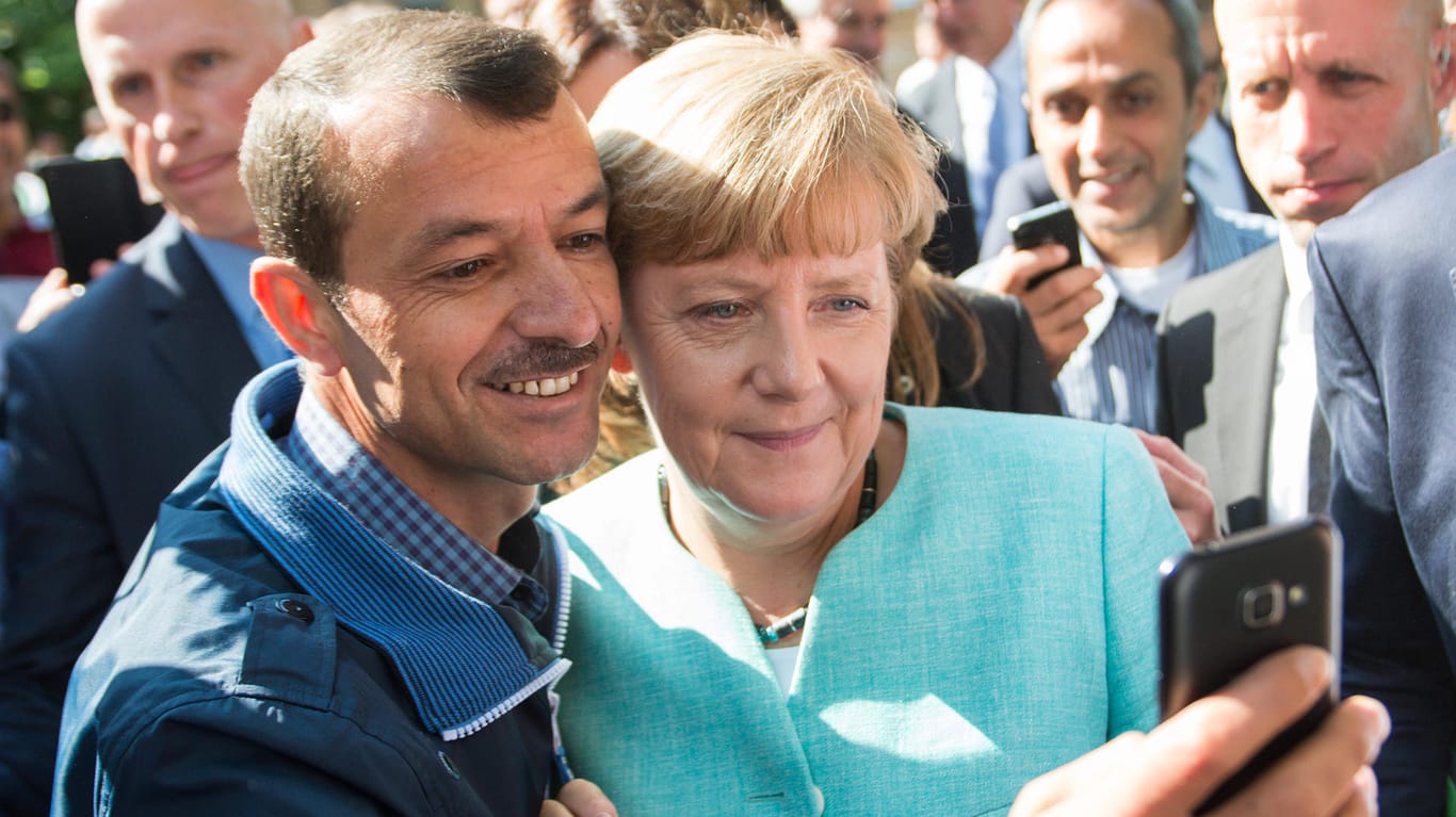 Bundeskanzlerin Angela Merkel (CDU) lässt sich im Jahr 2015 mit einem Flüchtling fotografieren: Statt um Willkommenskultur geht es in Europa heute um Abschottung.