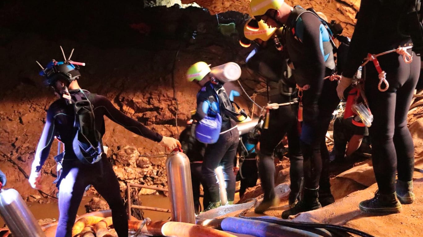Thailand, Chiang Rai: Mitglieder des thailändischen Rettungsteams, die in die Höhle hineingehen: Taucher unterbrachen die Rettungsaktion am Sonntagabend zunächst, um Luftvorräte aufzufüllen.