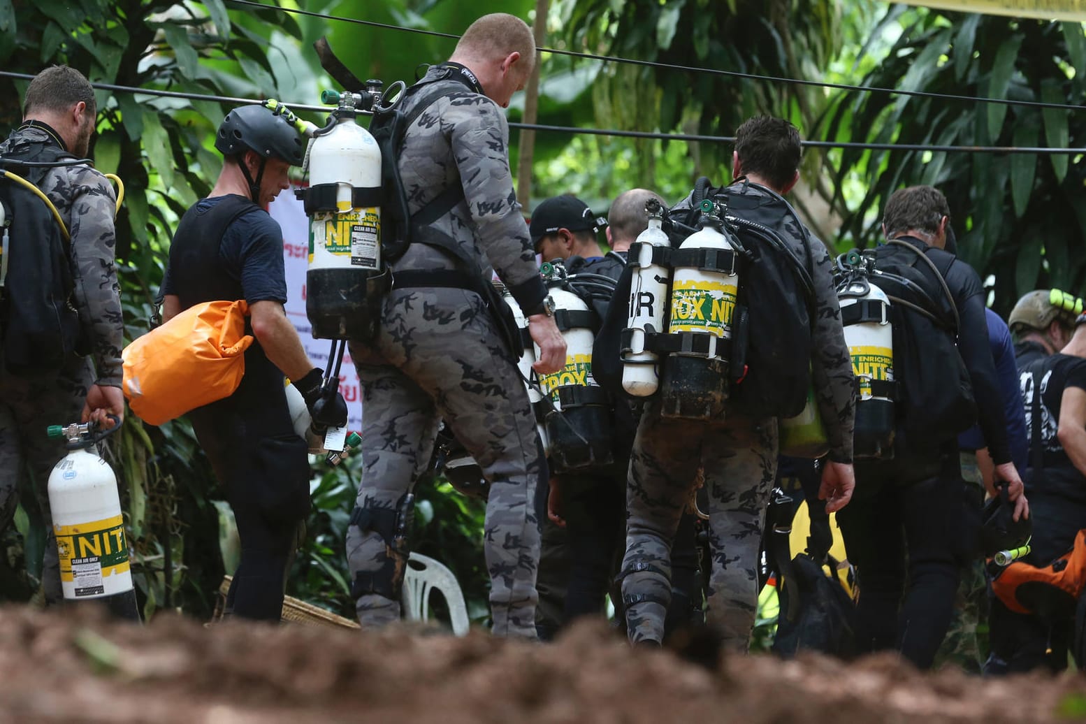 Taucher eines Rettungsteams vor dem Eingang der Höhle, in dem Jugendliche und ihr Trainer eingeschossen sind: Die Eingeschlossenen bekamen schon ersten Tauchunterricht, um die Höhle in Begleitung von Tauchern verlassen zu können.