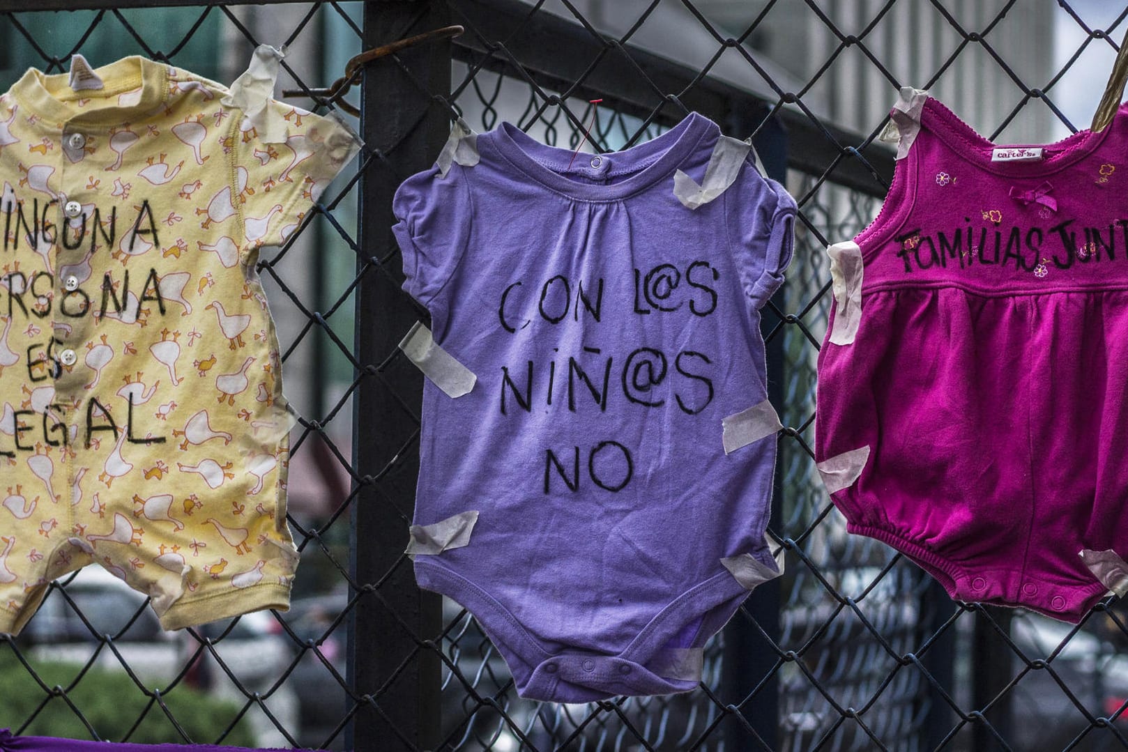 Kinderkleidung an einem Zaun in Mexiko: "Kein Mensch ist illegal" (l), "Familien (gehören) zusammen" (r), steht auf Strampelanzügen bei einem Protest gegen die US-Migrationspolitik vor der US-Botschaft in der mexikanischen Hauptstadt.