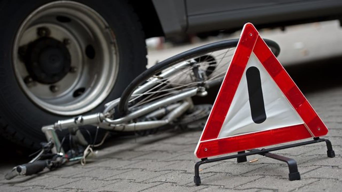 Ein Fahrrad liegt zu Anschauungszwecken bei einer Verkehrserziehungswoche für Schulen unter den Hinterrädern eines Lkw.