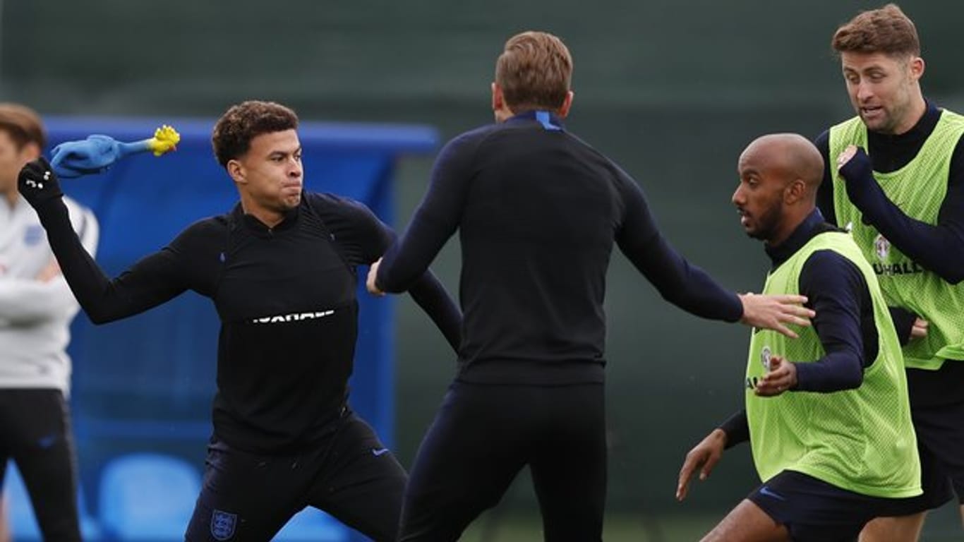 Englands Nationalspieler Dele Alli (l) wirft ein Gummihuhn.