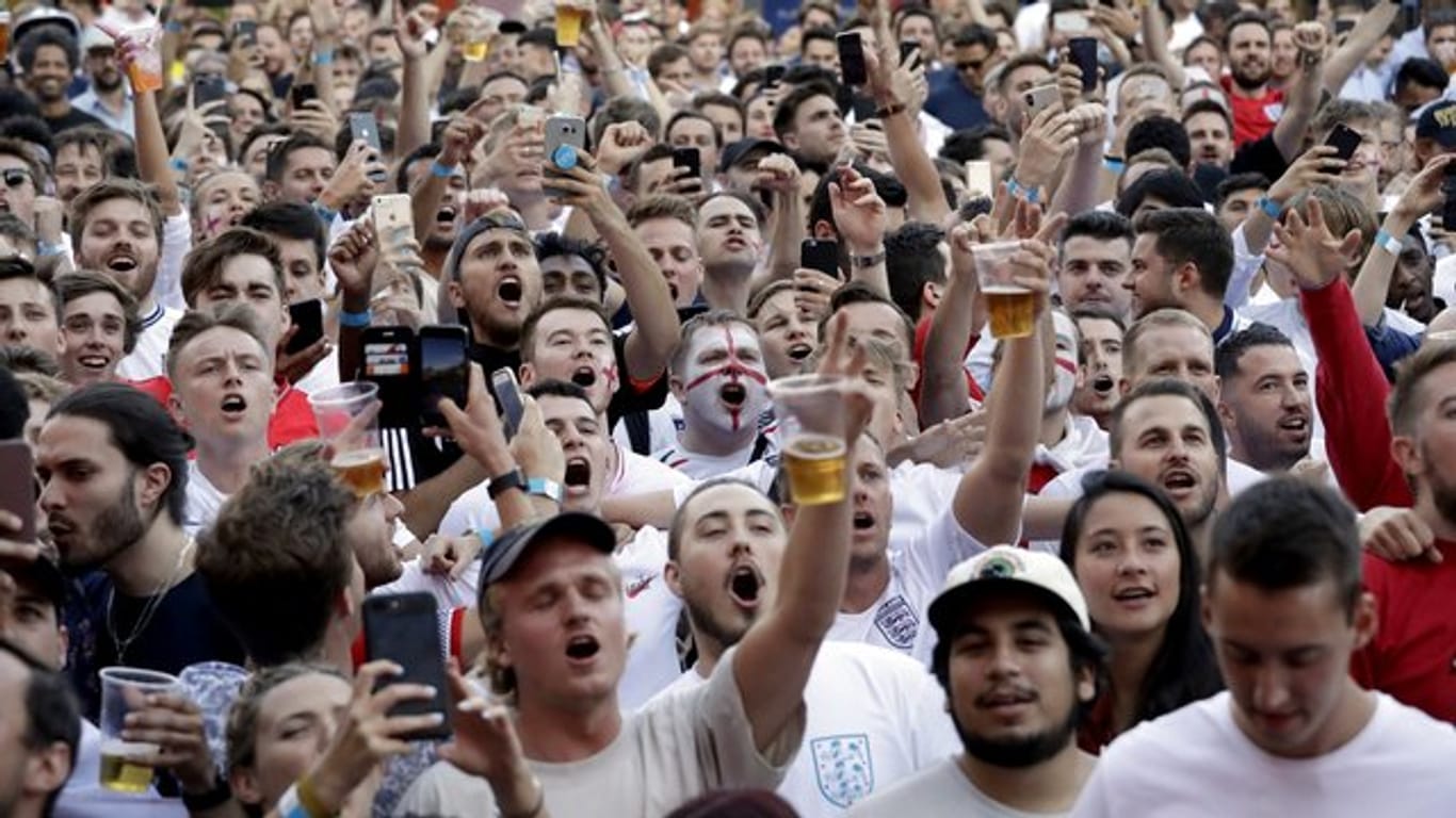 Fans der englischen Nationalmannschaft jubeln bei einem Public Viewing, während die britische Nationalhymne gesungen wird.