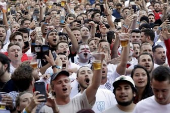 Fans der englischen Nationalmannschaft jubeln bei einem Public Viewing, während die britische Nationalhymne gesungen wird.