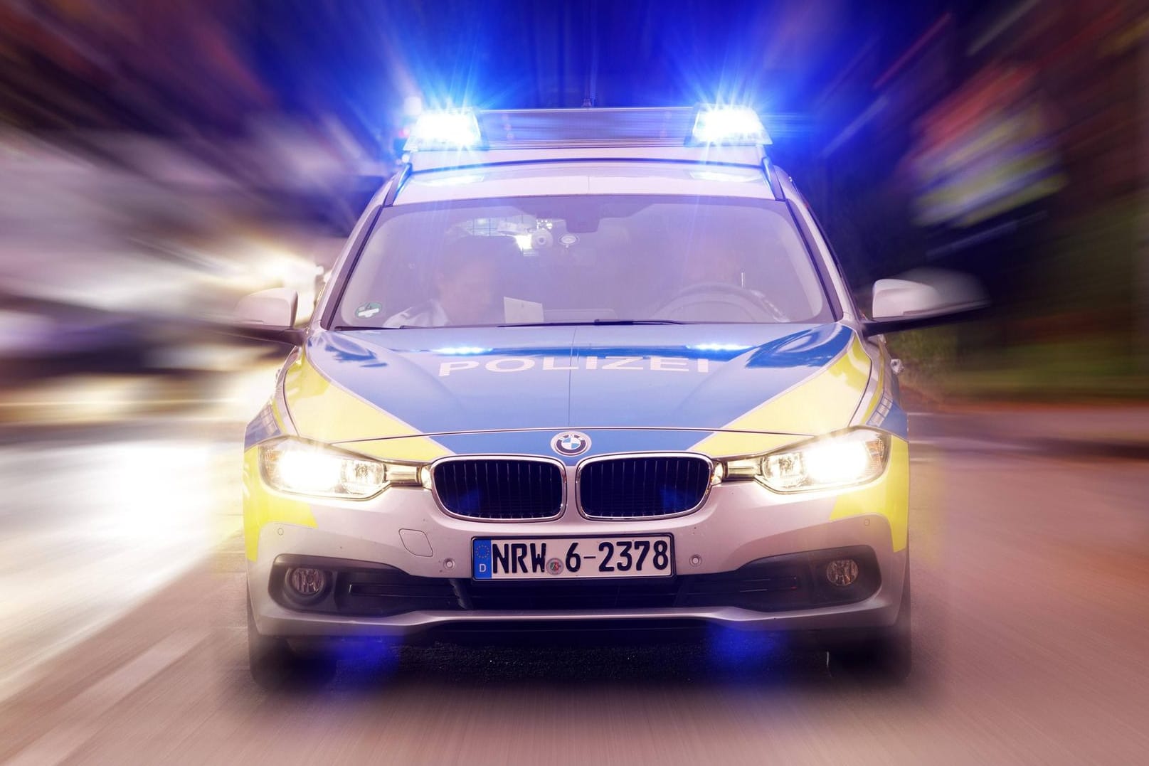Ein fahrendes Polizeiauto: Nachdem sich ein Mann bei einem Einbruch das Bein gebrochen hat, wurde er unter polizeilicher Aufsicht ins Krankenhaus gebracht.