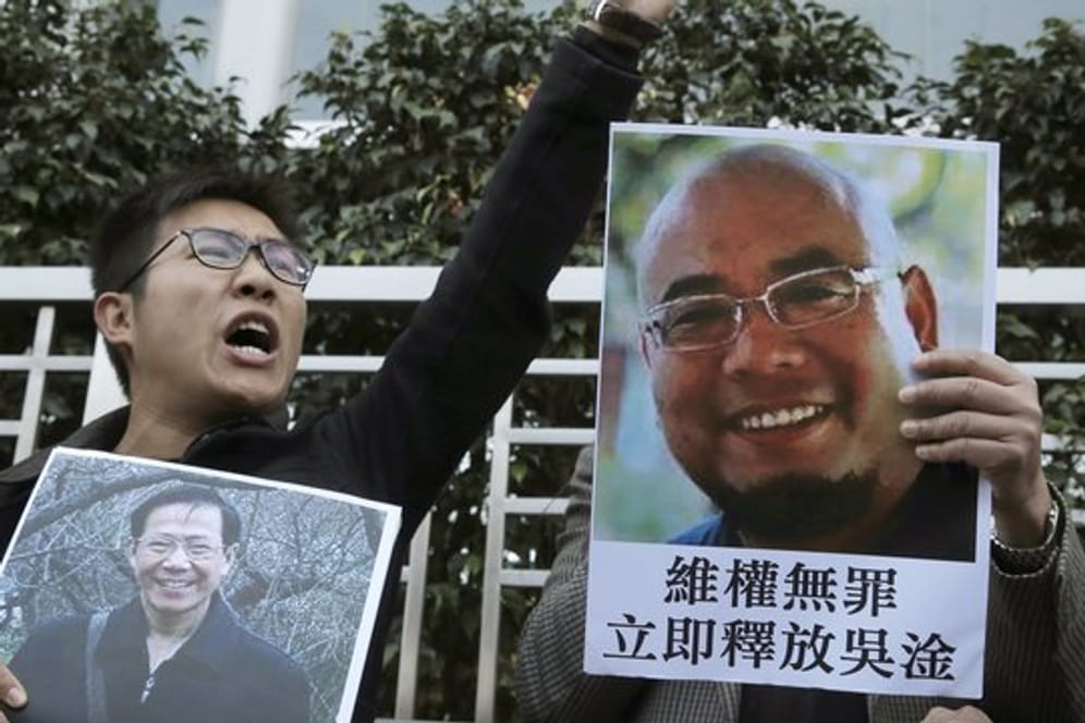 In Hongkong demonstrieren Bürger mit Bildern der Regierungskritiker Qin Yongmin (l) und Wu Gan für mehr Demokratie.