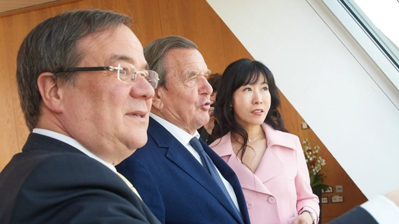 NRW-Ministerpräsident Armin Laschet (l-r), Alt-Bundeskanzler Gerhard Schröder und seine damalige Freundin und heutige Ehefrau Soyeon Kim in Düsseldorf.