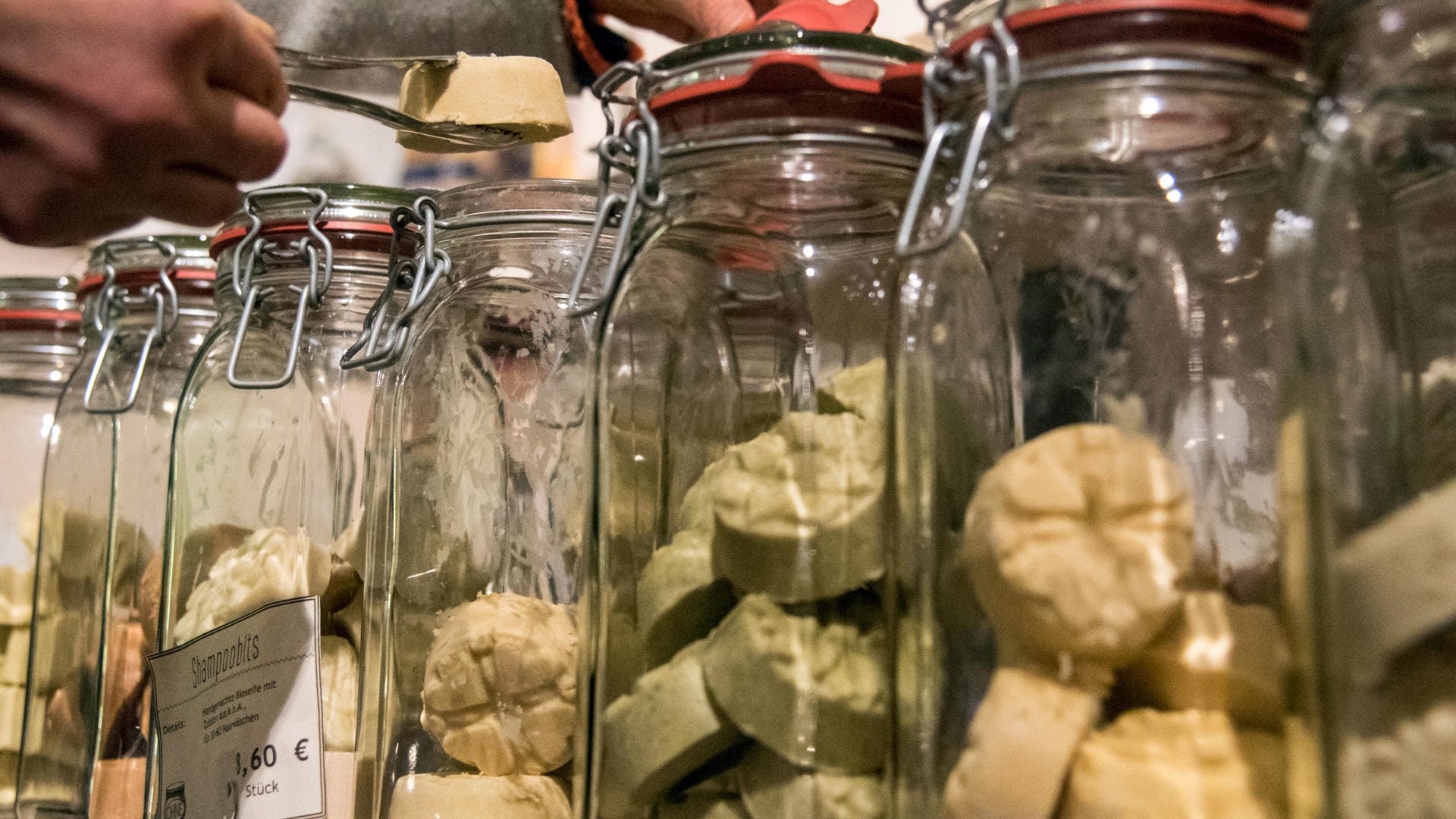 Verpackungsfreier Supermarkt: Eine Kundin nimmt sich im verpackungsfreien Laden "Ohne" in München ein Stück Shampoo aus einem Glas.