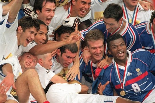 Die französischen Spieler um ihren Kapitän Didier Deschamps (M/lachend) und den zweifachen Finaltorschützen Zinedine Zidane (links daneben) jubeln mit dem WM-Weltpokal.