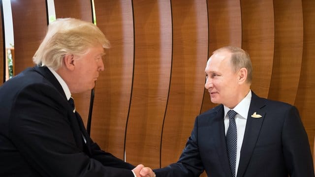 US-Präsident Donald Trump (l) und der russische Präsident Wladimir Putin schütteln sich beim G20-Gipfel in Hamburg die Hände.