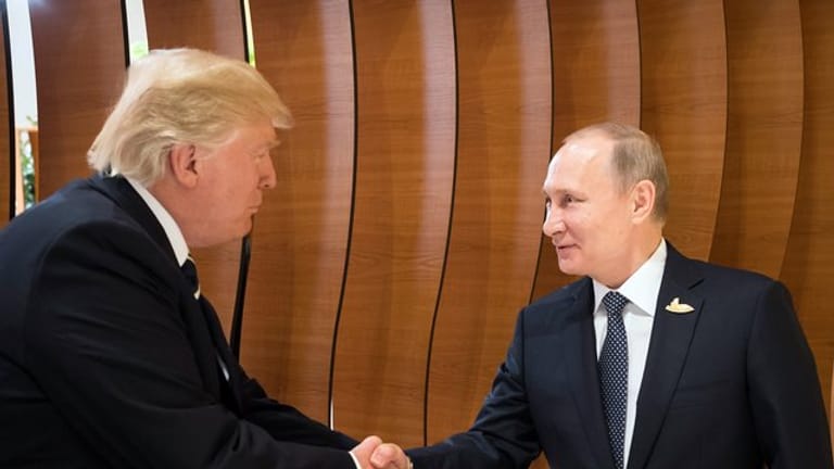 US-Präsident Donald Trump (l) und der russische Präsident Wladimir Putin schütteln sich beim G20-Gipfel in Hamburg die Hände.