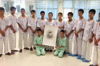 Die geretteten Höhlenjungs halten ein Bild des verstorbenen Tauchers hoch: Saman Kunan starb bei der Rettungsaktion in Thailand.
