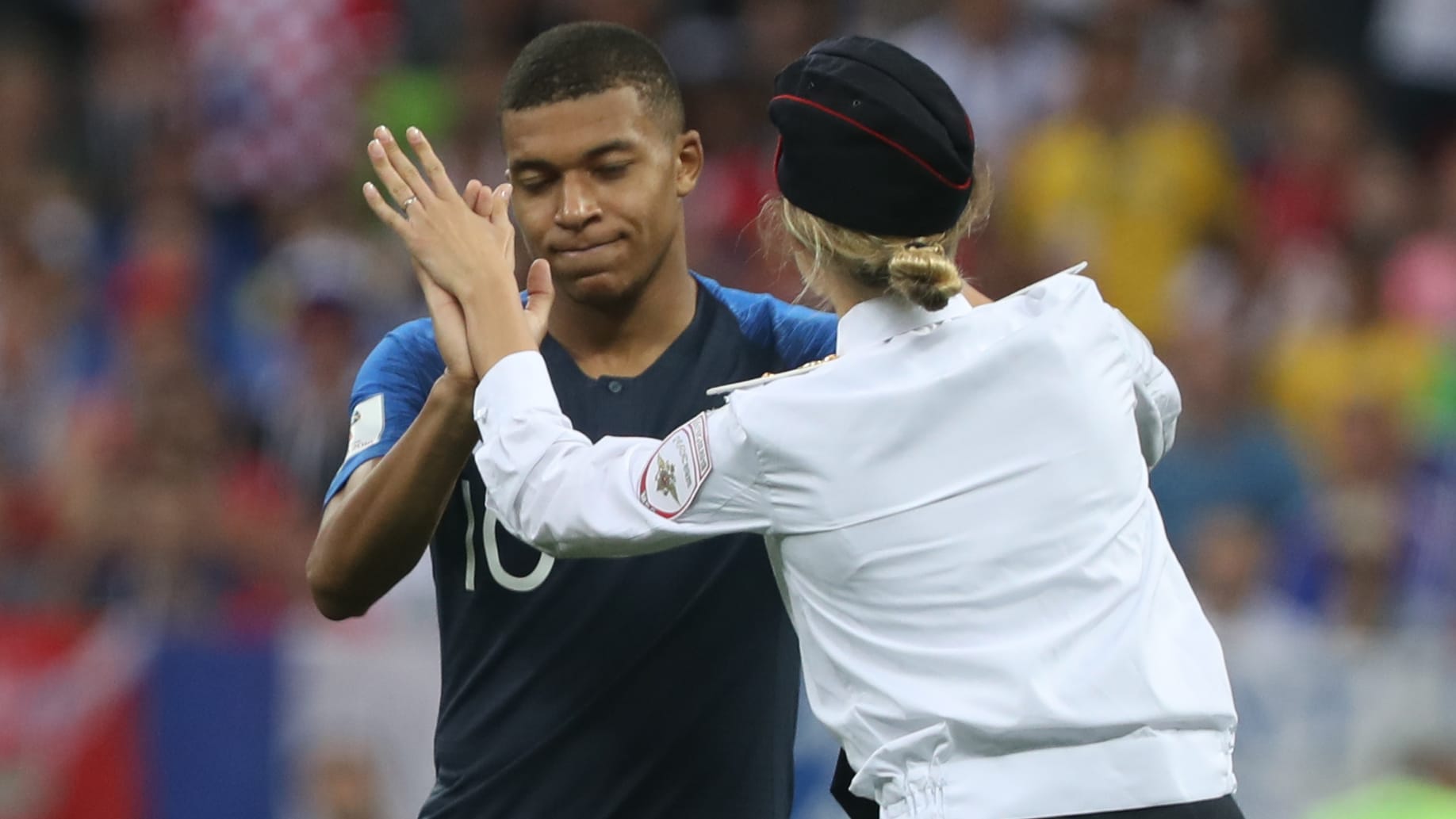 Kylian Mbappé schlägt mit einer der Flitzerinnen ein: Sicherheitsleute brachten die Störer schnell vom Spielfeld.