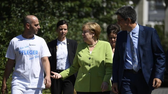 Pfleger Ferdi Cebi, Bundeskanzlerin Angela Merkel und Martin Wolf, Vorstand vom St. Pfleger Ferdi Cebi, Bundeskanzlerin Angela Merkel und Martin Wolf, Vorstand vom St.
