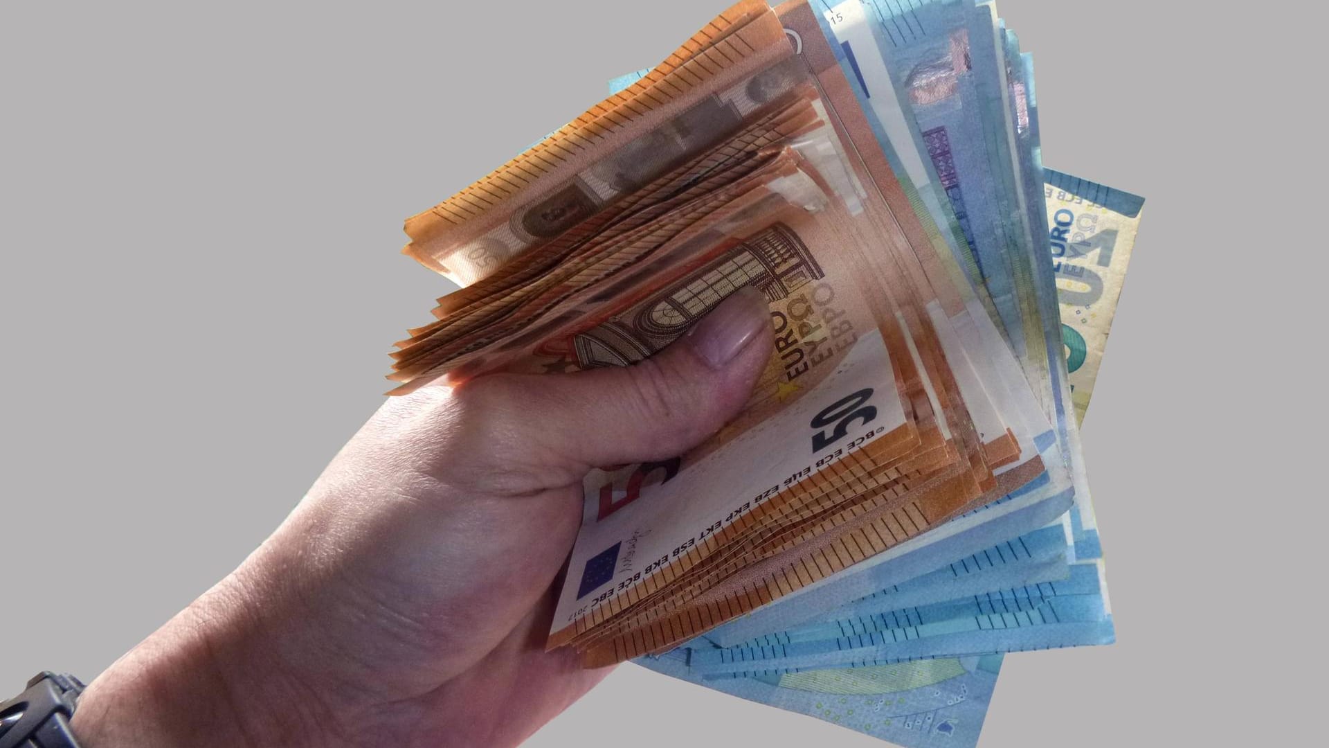 Eine Person hält Banknoten der Werte 50 und 20 Euro in großer Zahl in der Hand Eine Person hält Banknoten der Werte 50 und 20 Euro in großer Zahl in der Hand