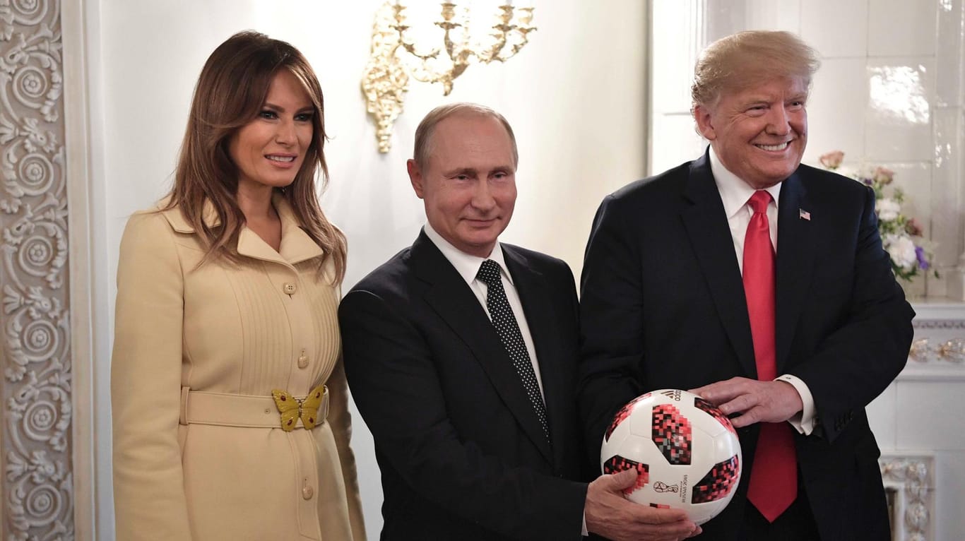 Ein WM-Ball als Gastgeschenk: Wladimir Putin, Donald Trump und Melania Trump beim Gipfeltreffen in Helsinki.