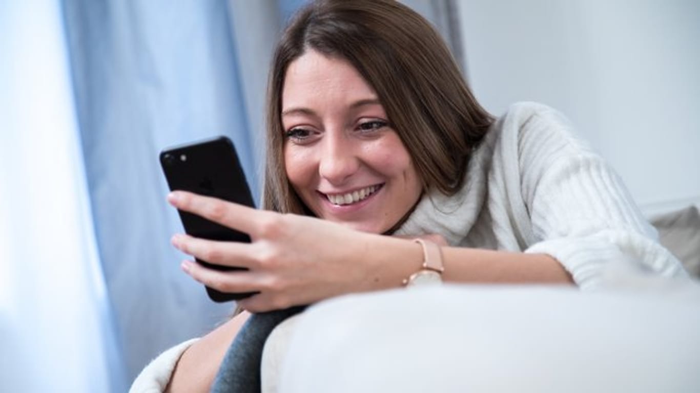 Frau mit Smartphone: Rund 18,2 Millionen Menschen spielen inzwischen mehr oder weniger regelmäßig auch auf ihrem Smartphone Videospiele.