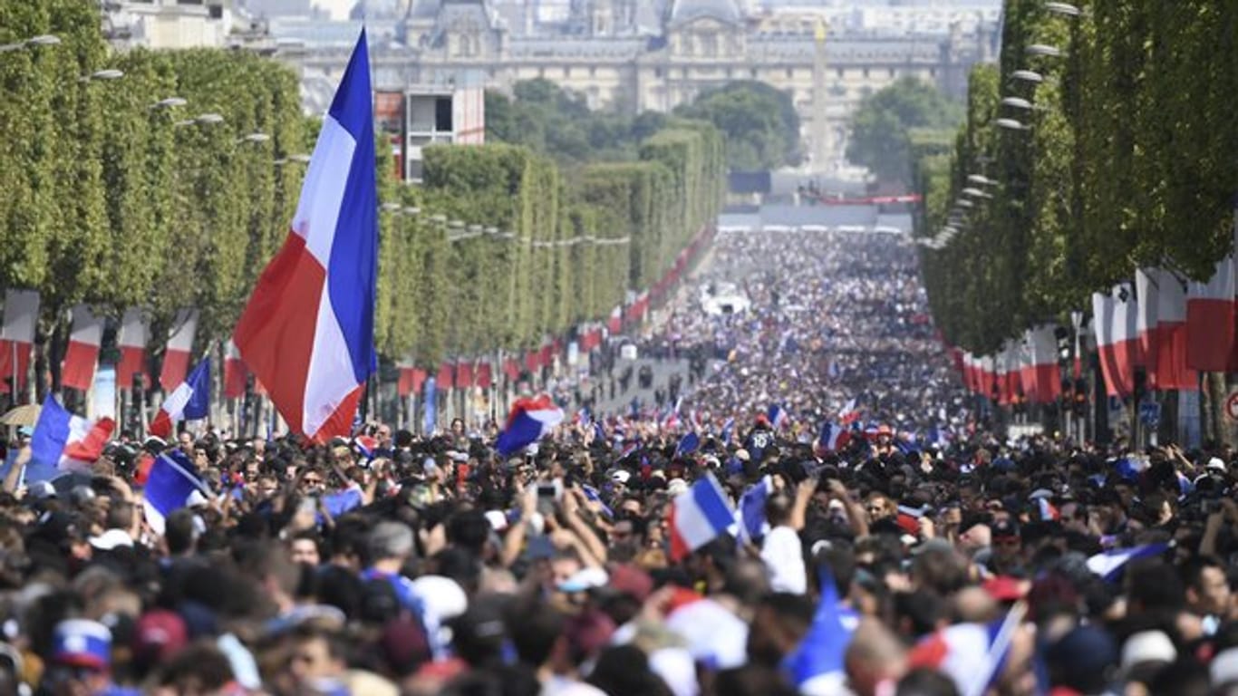Stundenlang harrten die Menschen auf den Champs-Élysées aus um dann nur einen kurzen Blick auf die Weltmeister werfen zu können.