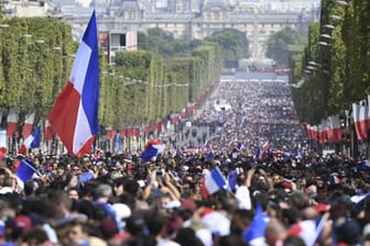 Stundenlang harrten die Menschen auf den Champs-Élysées aus um dann nur einen kurzen Blick auf die Weltmeister werfen zu können.