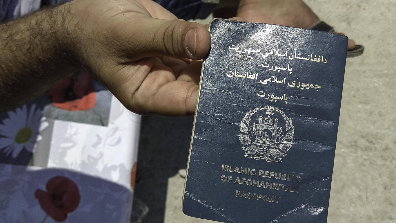 In einem griechischen Flüchtlingslager hält ein Mann einen afghanischen Pass in die Kamera (Archivbild): Die griechische Polizei hat Dutzende Migranten mit gefälschten Dokumenten erwischt.