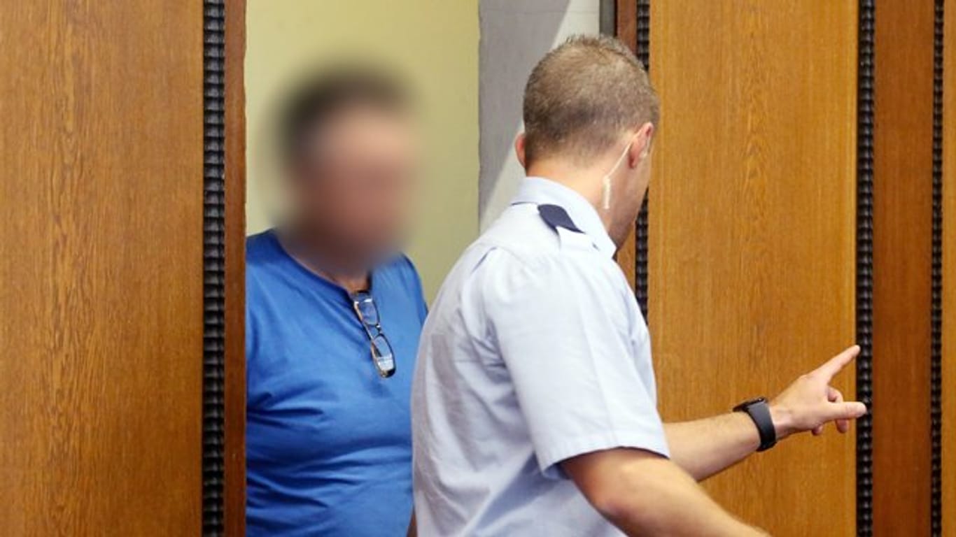 Der angeklagte Lkw-Fahrer (l) wird von einem Justizbeamten in den Gerichtssaal in Mönchengladbach geführt.