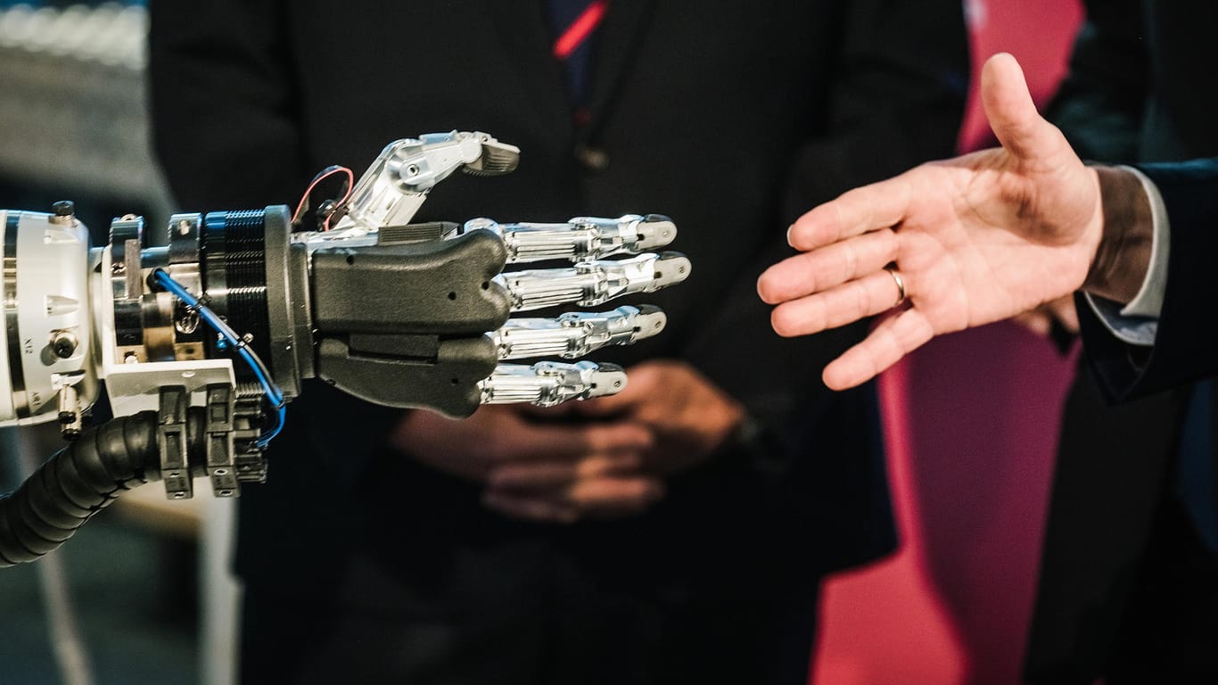 Eine menschliche und eine Roboterhand: Laut dem Plan der Regierung soll der Wissensaustausch zwischen Wissenschaft und Wirtschaft verstärkt werden. (Archivbild)