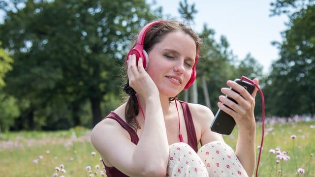 Frau beim Musik hören Wichtig für guten Smartphoneklang ist ein ordentlicher Kopfhörer.