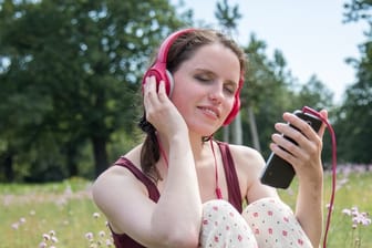 Frau beim Musik hören Wichtig für guten Smartphoneklang ist ein ordentlicher Kopfhörer.