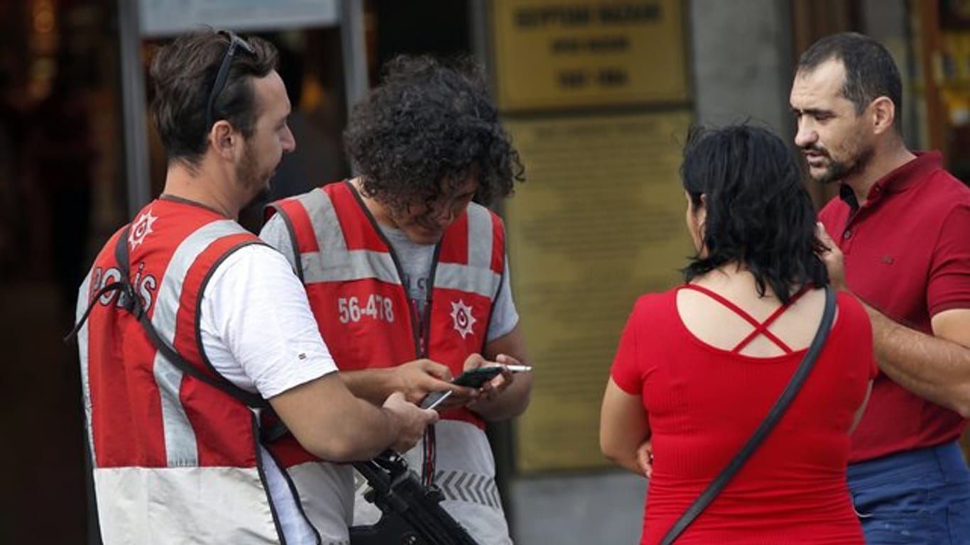 Türkische Polizeibeamte überprüfen die Dokumente von Fußgängern in Istanbul.