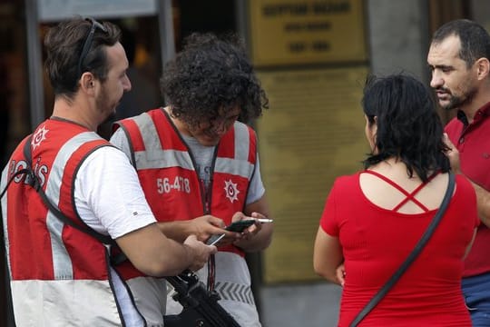 Türkische Polizeibeamte überprüfen die Dokumente von Fußgängern in Istanbul.