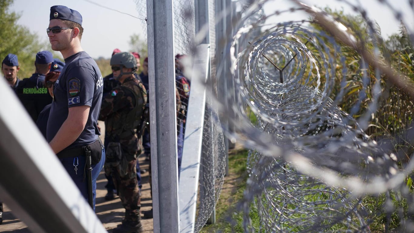 Ungarische Grenzpolizisten an der Grenze zu Serbien: Die EU beklagt unter anderem, dass Geflüchtete zu lange in Transitzonen festgehalten werden.