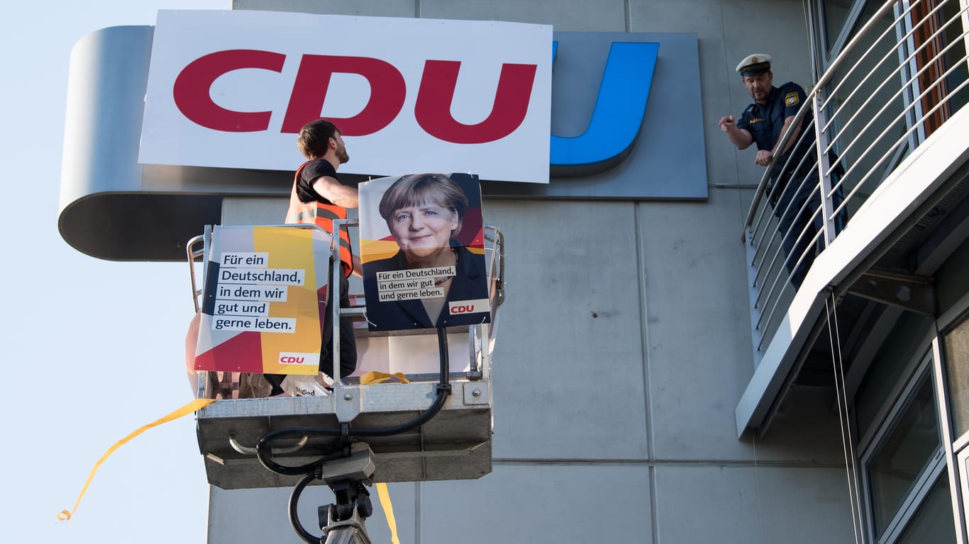 Ein Demonstrant bringt ein Logo der CDU an der CSU-Zentrale an: Zwei Demonstranten haben für die Aktion eine Anzeige kassiert.