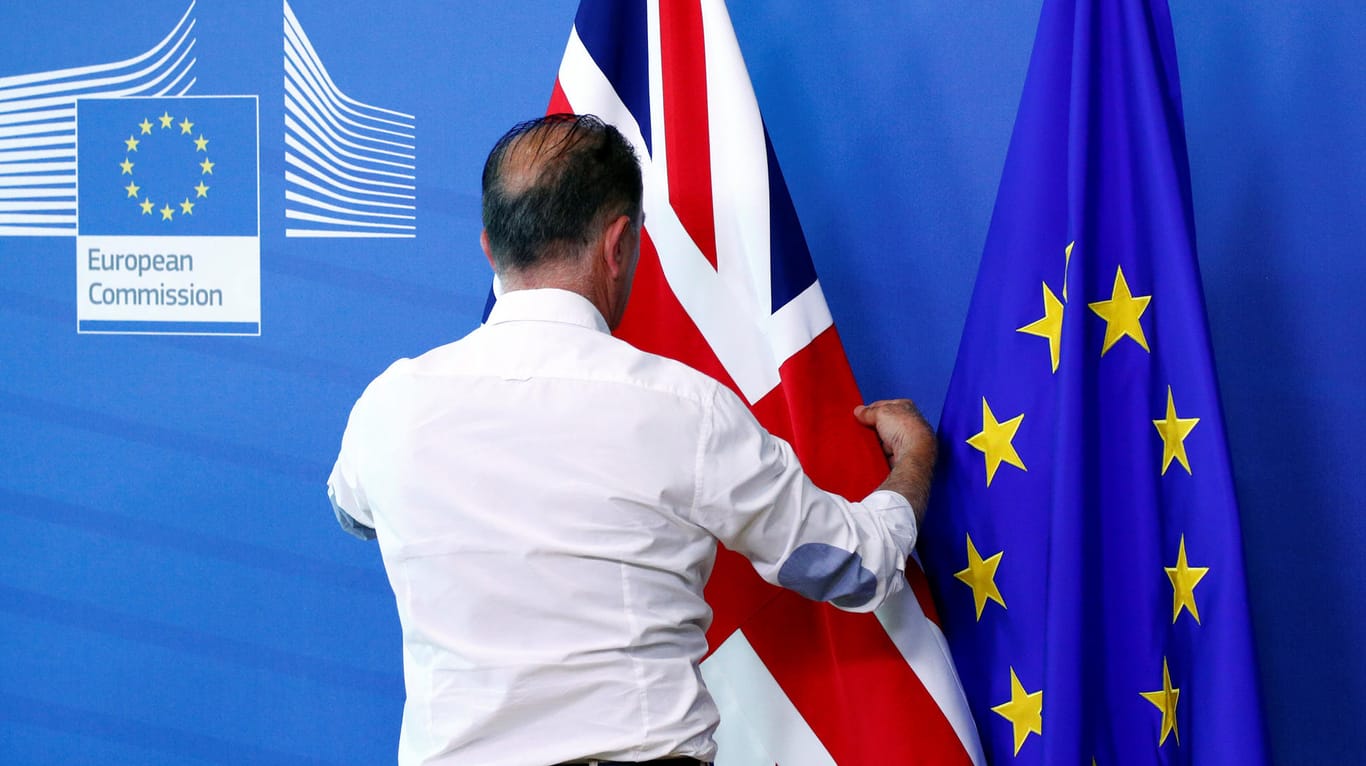 Ein Mann richtet die britische Flagge: Ein unkontrollierter Brexit würde die europäische Wirtschaft hart treffen, hat der Internationale Währungsfonds berechnet.