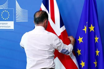 Ein Mann richtet die britische Flagge: Ein unkontrollierter Brexit würde die europäische Wirtschaft hart treffen, hat der Internationale Währungsfonds berechnet.