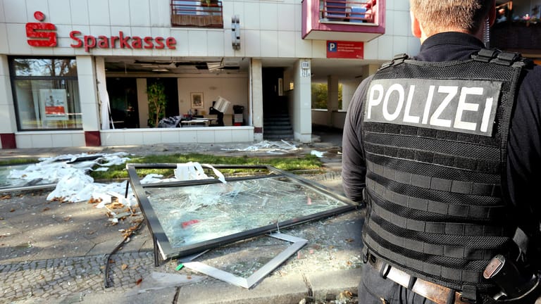 Ein Polizist vor einer zerstörten Sparkassenfiliale in Berlin: In der Filiale war eine Explosion ausgelöst und Schließfächer ausgeräumt worden.