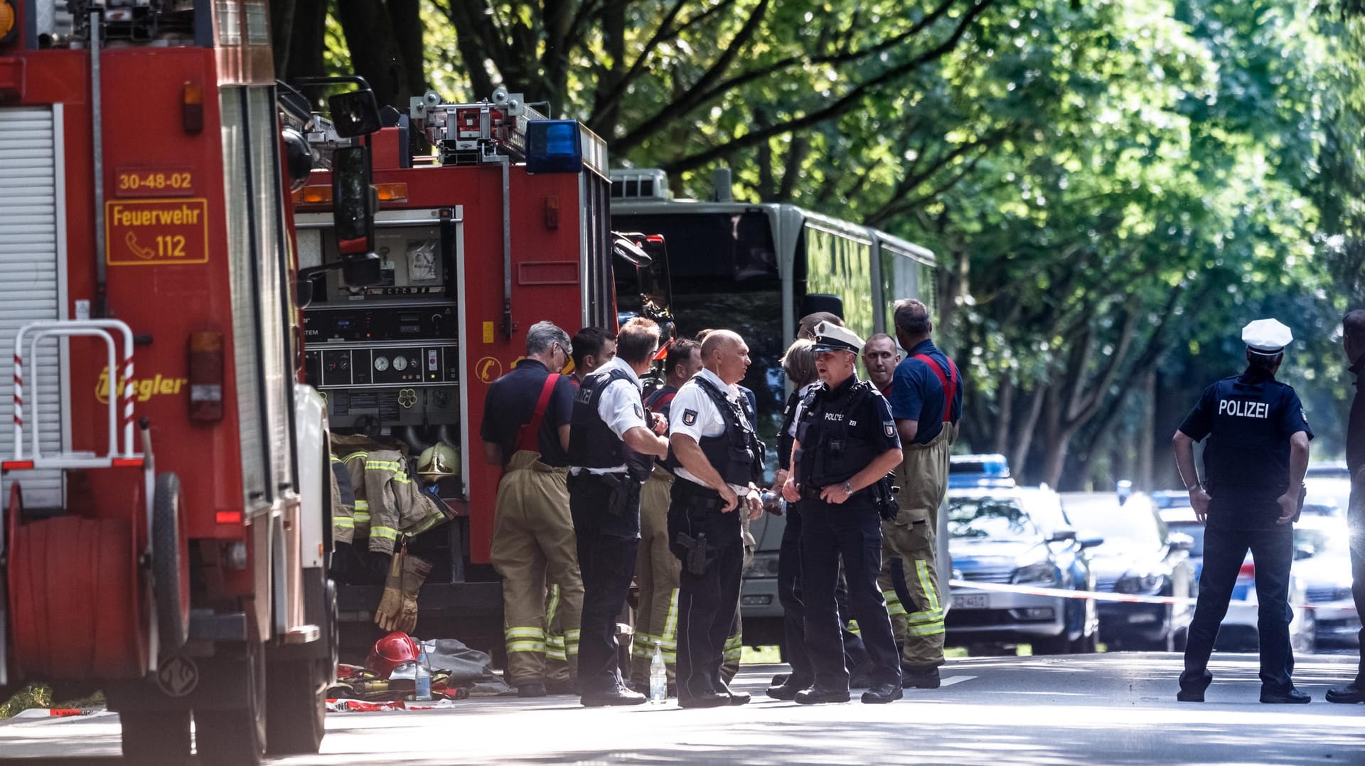 Der Tatort in Lübeck: Einsatzkräfte stehen vor dem Bus in dem ein Fahrgast Mitreisende mit einem Messer attackiert hat.