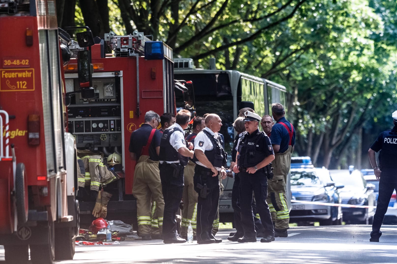 Der Tatort in Lübeck: Einsatzkräfte stehen vor dem Bus in dem ein Fahrgast Mitreisende mit einem Messer attackiert hat.
