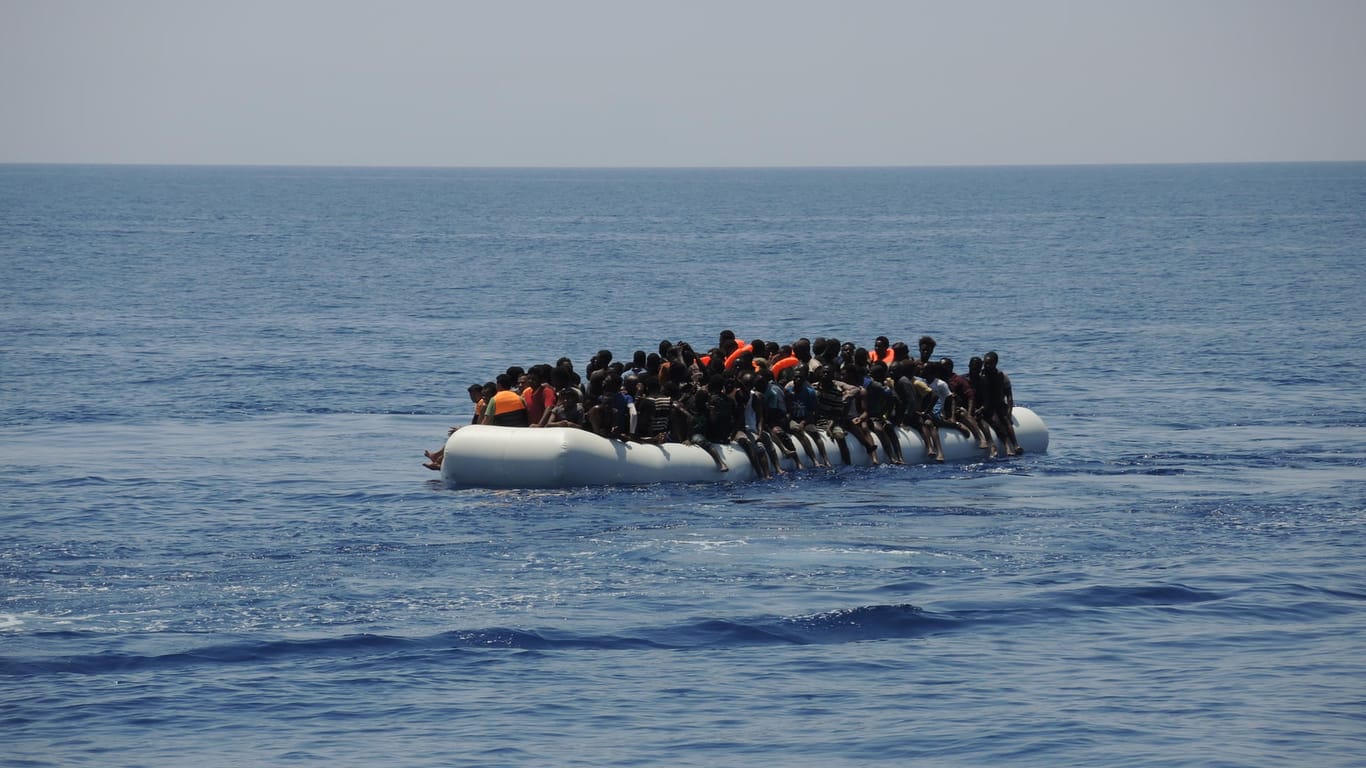 Migranten sitzen auf einem überladenen Schlauchboot im Mittelmeer: Aufgrund der Blockade Italiens, haben es Rettungsschiffe aktuell schwer, einen sicherer Hafen in Europa zu finden.