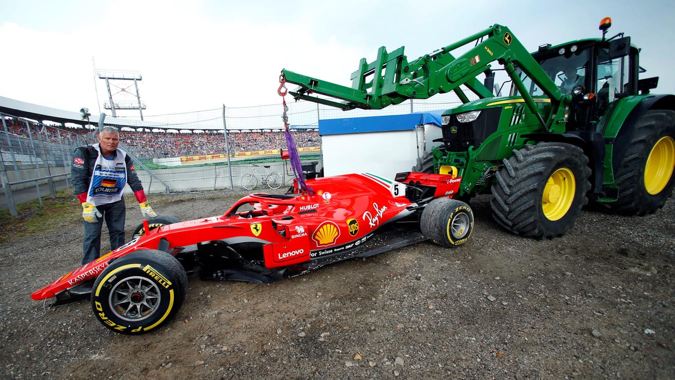 Mit einem Traktor muss Sebastian Vettels Auto von der Strecke abtransportiert werden.