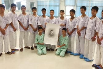 Die geretteten Jungen mit einem Bild des Tauchers der Thai Navy Seals, der bei ihrer Befreiung gestorben ist: In einem Kloster sollen die Jungen zu Novizen ernannt werden.