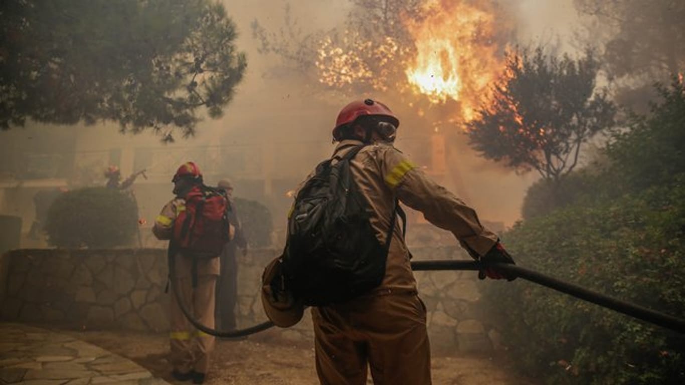 Feuerwehrleute bekämpfen einen Waldbrand in der Nähe von Athen.