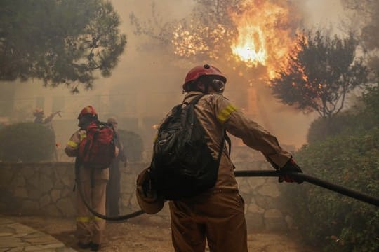 Feuerwehrleute bekämpfen einen Waldbrand in der Nähe von Athen.