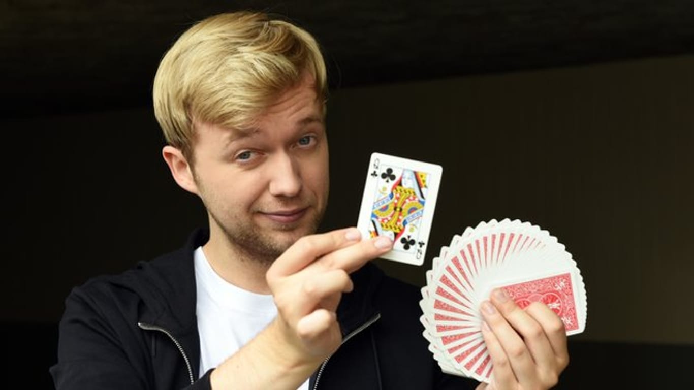 Der Zauberer Marc Weide hat die Karten in der Hand.
