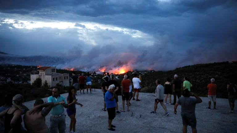 Außer Kontrolle: In Rafina bei Athen beobachten Einwohner, wie sich die Flammen in den Ort fressen.