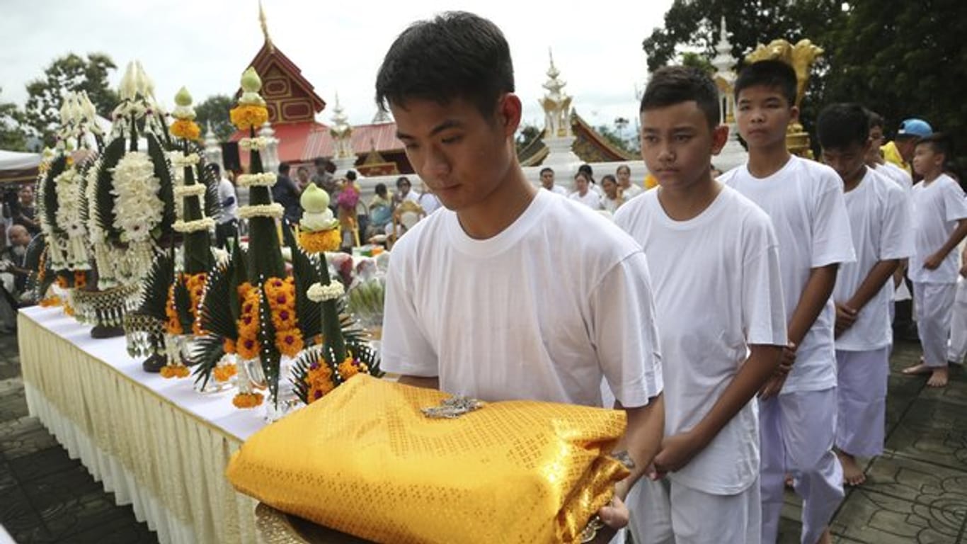 Trainer Ekkapol Chantawong (l) und einige der geretteten Spieler während einer buddhistischen Zeremonie in Chiang Rai.