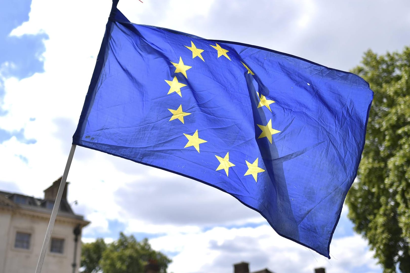 Eine wehende EU-Flagge: Die EU-Kommission hat Millionenstrafen gegen namhafte Konzerne wegen Preisverzerrungen im Online-Handel verhängt.
