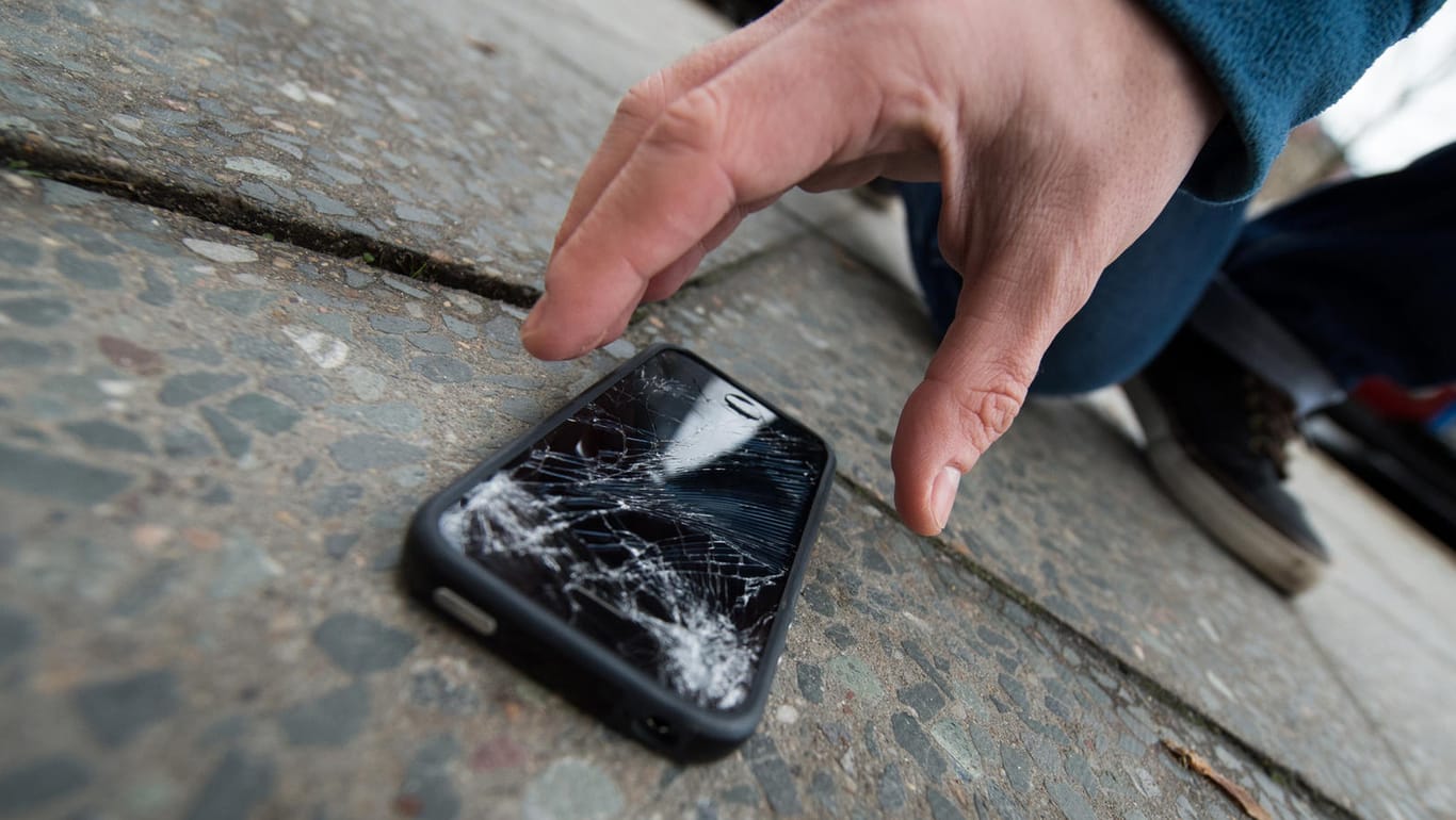 Typischer Unfall: Ein Sturz auf den Asphalt - schon ist das Smartphone-Display kaputt: Bei Gorilla-Glas soll das zumindest seltener vorkommen.