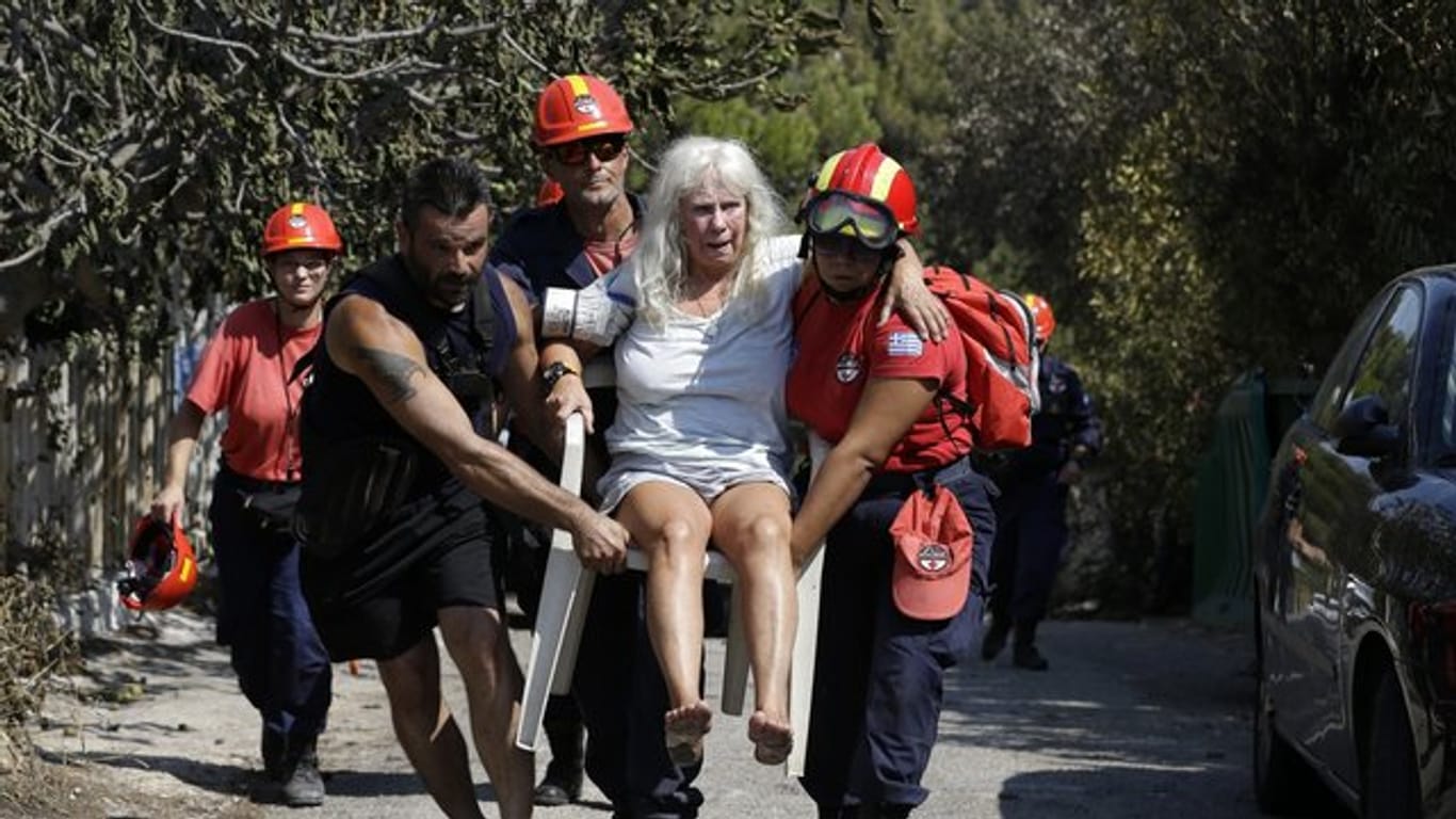 Mitglieder eines Rettungsteams tragen in Mati eine verletzte Frau.