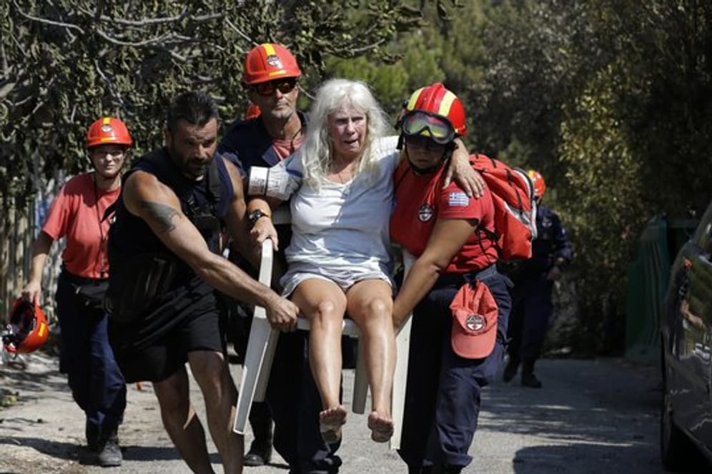 Mitglieder eines Rettungsteams tragen in Mati eine verletzte Frau.